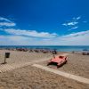 Spiaggia con ombrelloni e pedalò rosso.