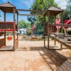 Bambini giocano su una struttura in legno in un parco giochi.