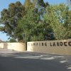 Ingresso del camping La Rocca con scritta su muro giallo.
