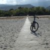 Bicicletta parcheggiata su un sentiero in una spiaggia sabbiosa.