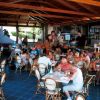 Persone sedute in un bar all'aperto sotto un tetto di legno.