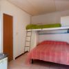 Camera con letto matrimoniale, letto a soppalco verde e piccolo lavello.