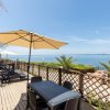 Terrazza con ombrelloni e sedie vista mare.