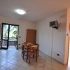 Cucina moderna con tavolo da pranzo, sedie e televisore.